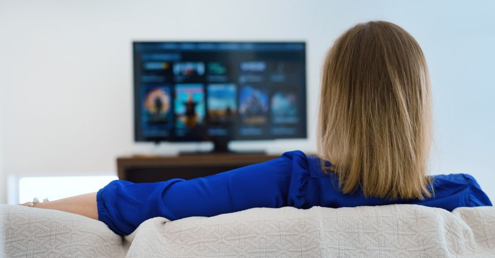 Mulher assistindo série para treinar inglês.