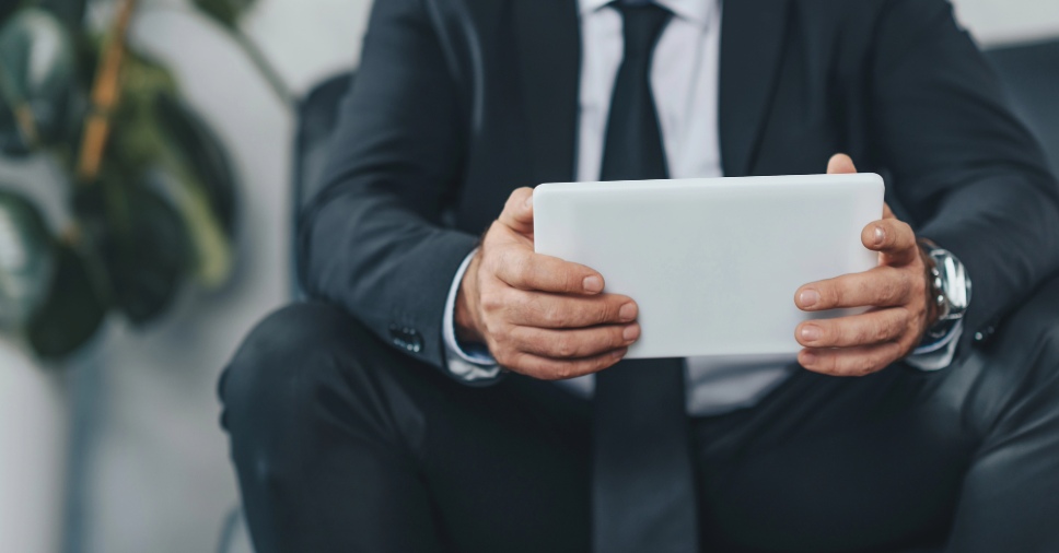 Homem usando tablet, sugerindo o uso de tecnologia para praticar trava-línguas em espanhol.