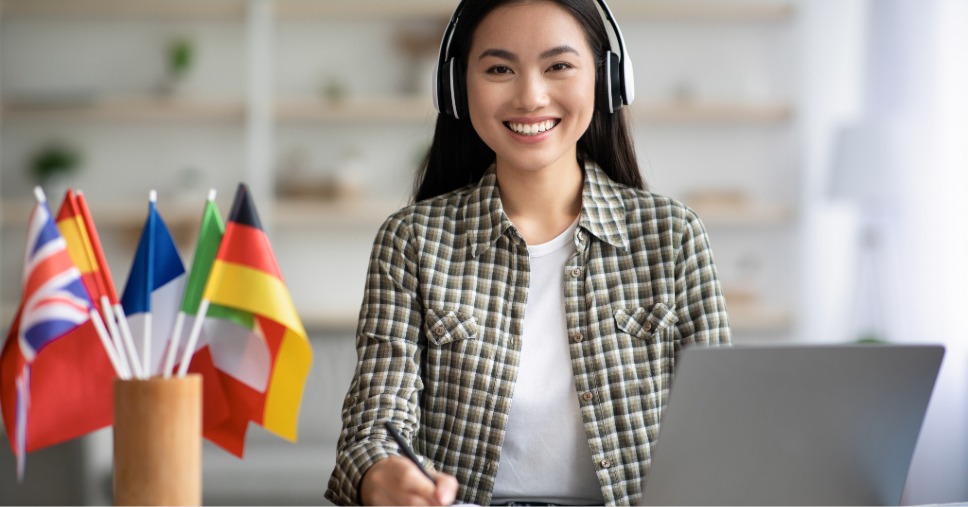 Mulher em frente ao computador, representando as oportunidades de uma carreira internacional remota.