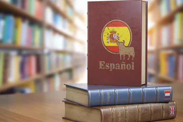 dois livros empilhados em cima da mesa na biblioteca, com destaque para o livro de espanhol neutro em pé