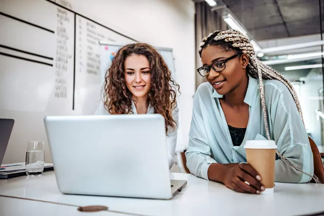 Duas mulheres estudam inglês para empresas no computador